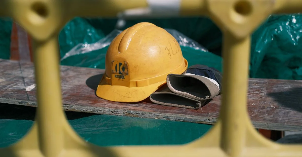 Gros plan sur un casque de chantier jaune posé sur un établi sur un chantier.